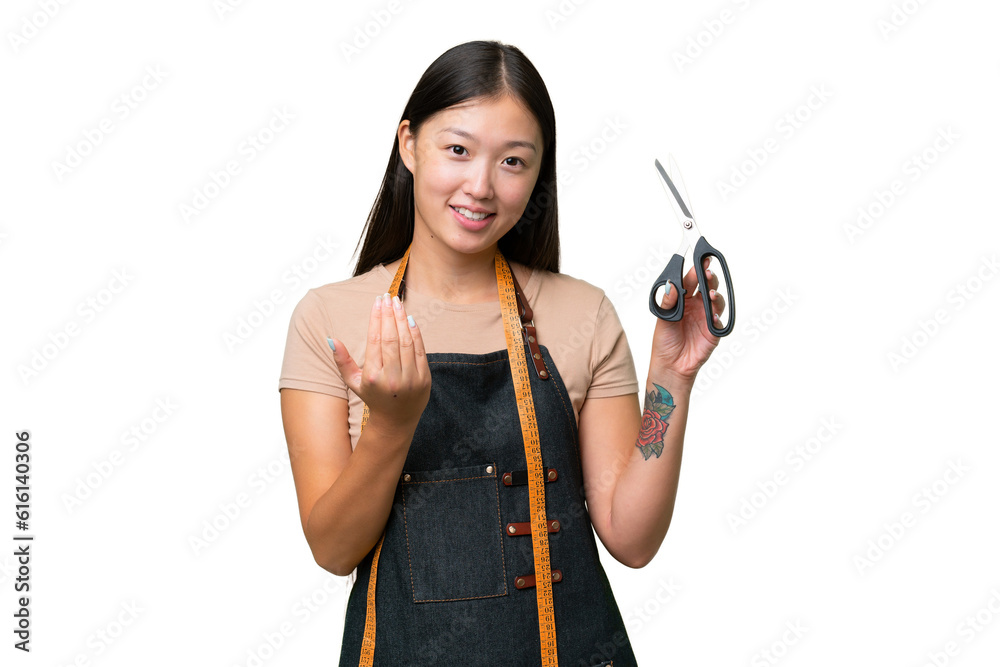 Young Asian seamstress woman over isolated background inviting to come with hand. Happy that you came Young Asian seamstress woman over isolated background inviting to come with hand. Happy that you came