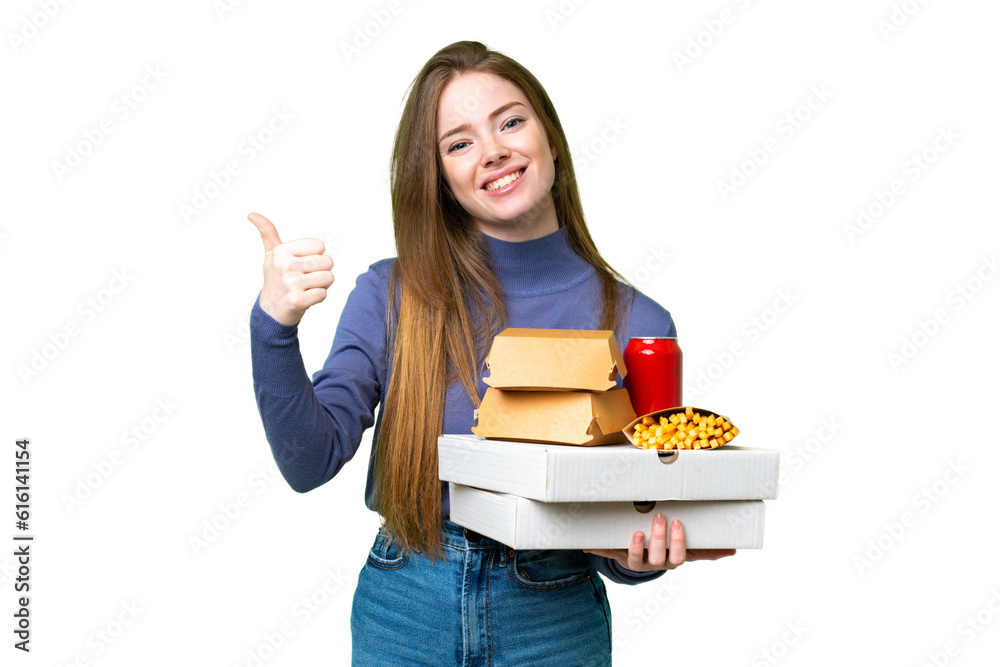 Young pretty woman holding pizzas and burgers over isolated chroma key background with thumbs up because something good has happened Young pretty woman holding pizzas and burgers over isolated chroma key background with thumbs up because something good has happened