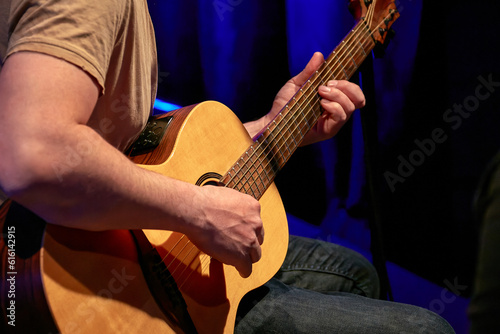 male hands playing acoustic guitar