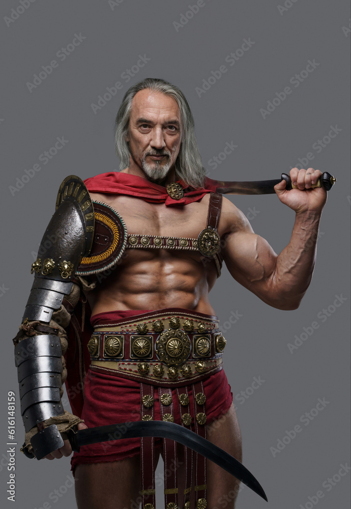 Distinguished elder gladiator exudes power and strength in elegant, lightweight armor, wielding two gladius swords with confidence against a grey background Distinguished elder gladiator exudes power and strength in elegant, lightweight armor, wielding two gladius swords with confidence against a grey background