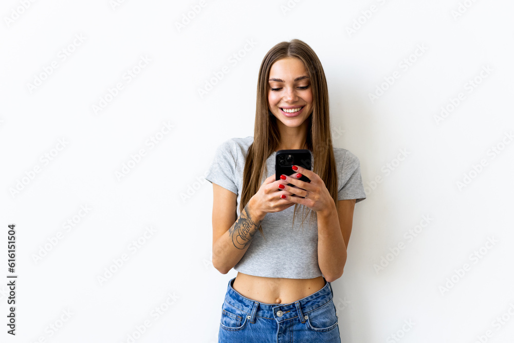 Young woman smiling while using cellphone isolated over white background Young woman smiling while using cellphone isolated over white background