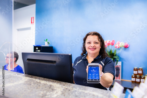 receptionist holding out EFTPOS machine for taking card payment for professional services photo