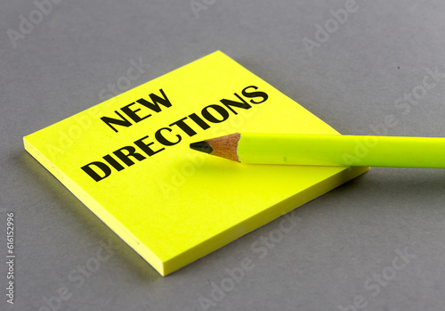 NEW DIRECTIONS text written on a sticky on grey background