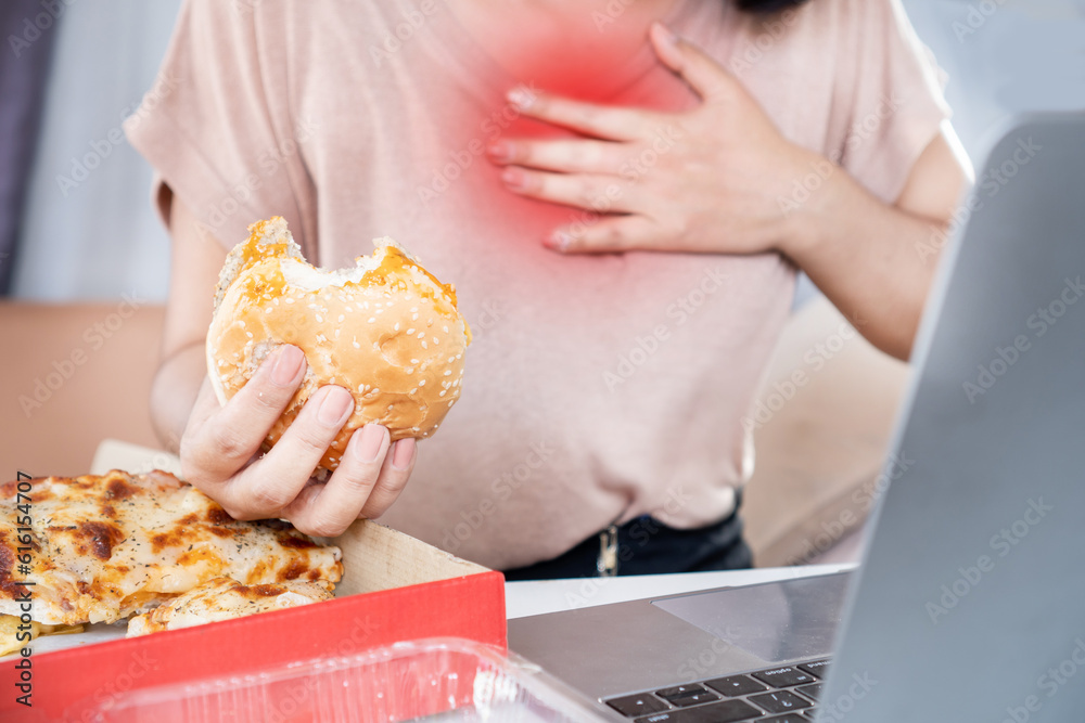 woman suffering from acid reflux , heartburn after over eating junk food, pizza and burger - obrazy, fototapety, plakaty 