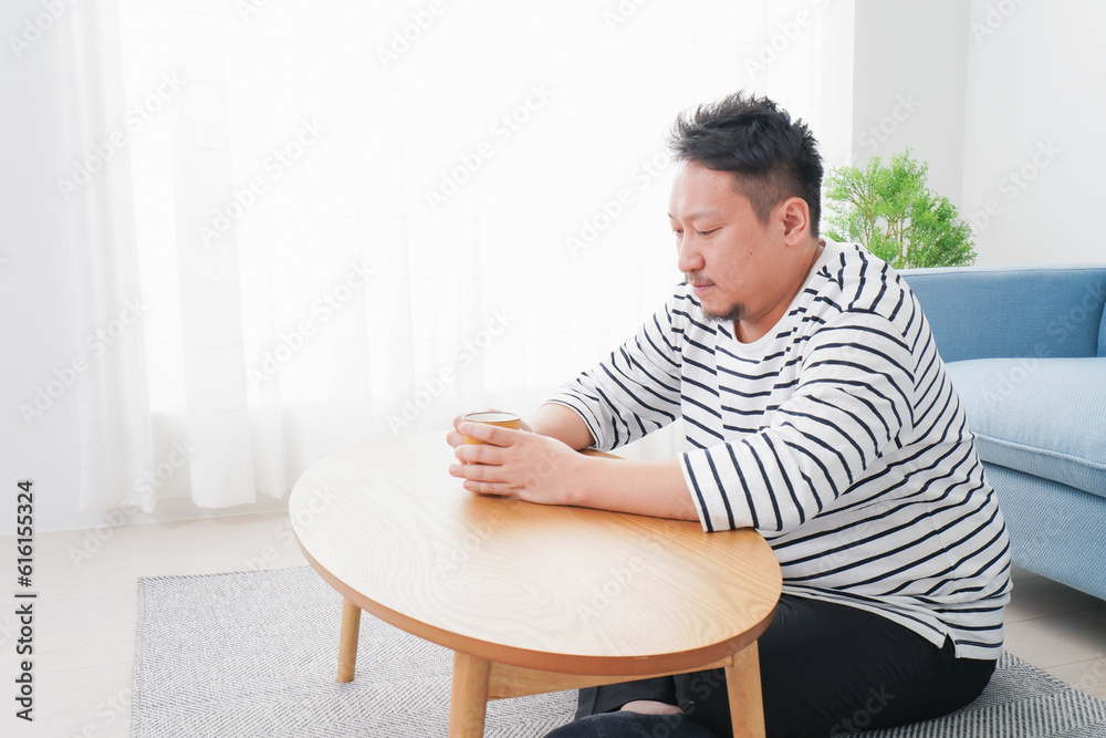 部屋でお茶を飲む中年男性 部屋でお茶を飲む中年男性