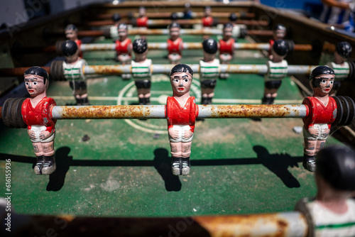 Vintage foosball table displaying Sport Lisboa e Benfica and Sporting Clube de Portugal teams in action.