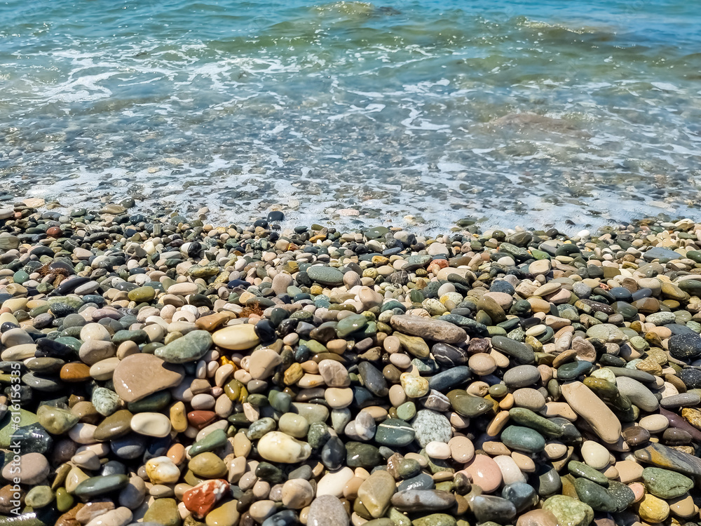 Stones on beach and sea water.Waves in sea near coastline on empty pebble beach. Coast pebbles. Shore landscape on Europe resort. Ocean shoreline scenic. Stones on beach and sea water.Waves in sea near coastline on empty pebble beach. Coast pebbles. Shore landscape on Europe resort. Ocean shoreline scenic.