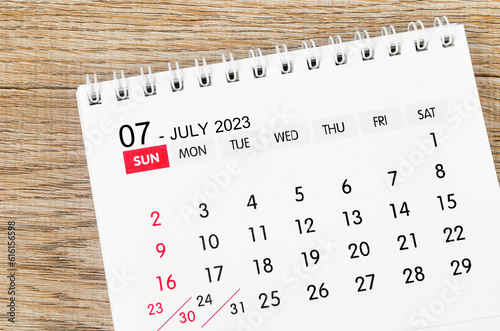 The July 2023 desk calendar for 2023 on wooden background.