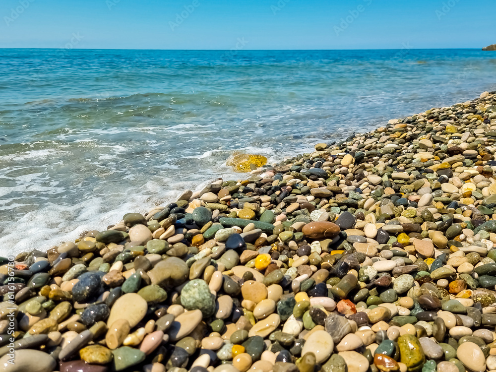 Stones on beach and sea water.Waves in sea near coastline on empty pebble beach. Coast pebbles. Shore landscape on Europe resort. Ocean shoreline scenic. Stones on beach and sea water.Waves in sea near coastline on empty pebble beach. Coast pebbles. Shore landscape on Europe resort. Ocean shoreline scenic.