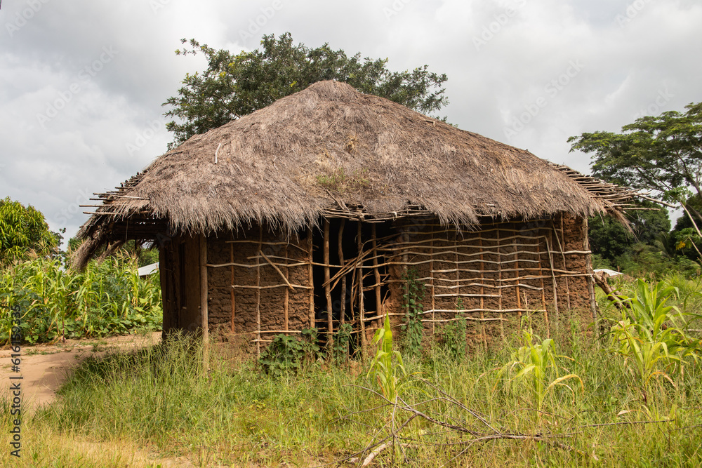 Typical rural mud-house in remote village in Africa with thatched roof, very basic and poor living conditions for local population