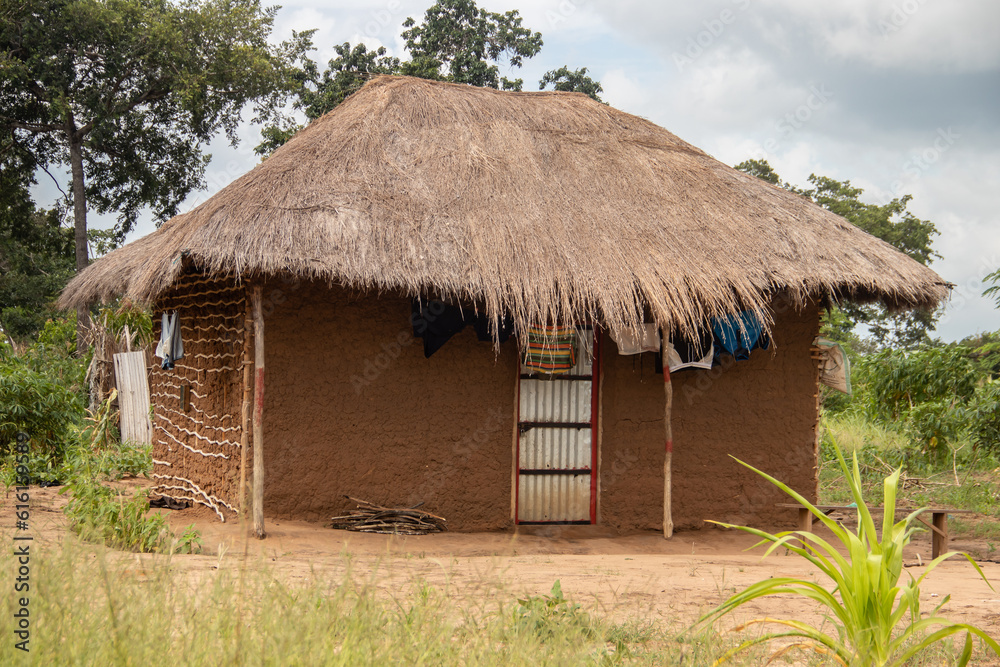 Typical rural mud-house in remote village in Africa with thatched roof, very basic and poor living conditions
