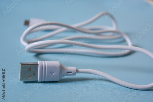 White folded usb and micro usb cable on blue background.