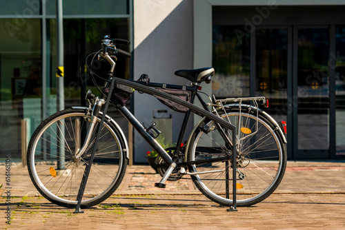 Classic black bicycle are parked in the metal bike parking