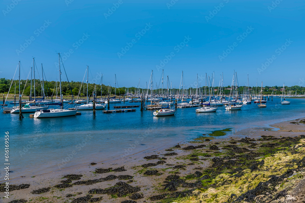 A view across boats moored at low tide on the River Hamble, Hampshire in summertime