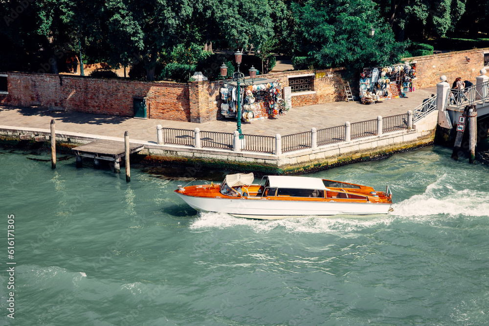 Fototapeta premium Vibrant Water Colors: A Boat on the Main Canal in Venice