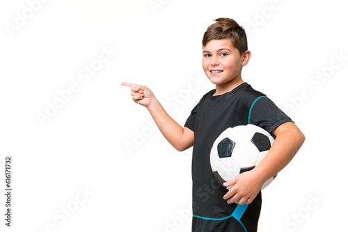 Little caucasian football player kid over isolated chroma key background pointing finger to the side