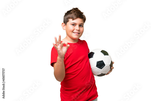 Fototapeta Naklejka Na Ścianę i Meble -  Little caucasian kid over isolated chroma key background with soccer ball and making OK sign
