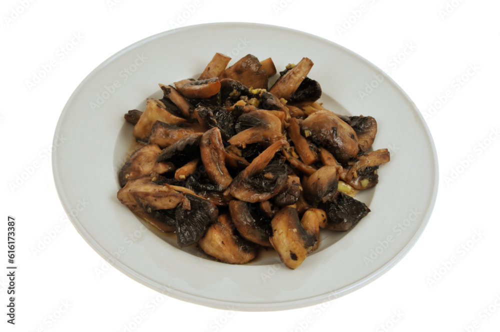 Assiette de champignons cuisinés avec de l'ail en gros plan sur fond blanc Assiette de champignons cuisinés avec de l'ail en gros plan sur fond blanc