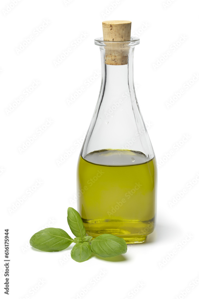 Glass bottle with homemade basil oil close up isolated on white background