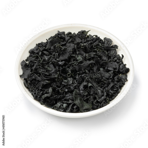 White bowl with dried wakame seaweed close up isolated on white background
