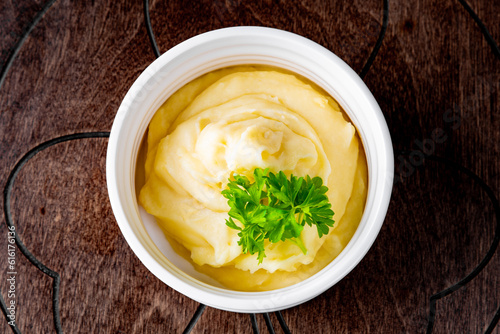 Fresh creamy mashed potato in white bowl on table photo