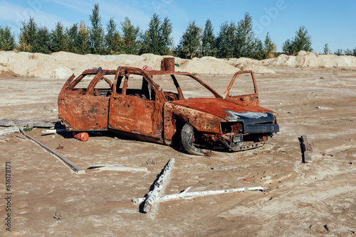 A burnt rusty civilian car with bullet holes. Russian-Ukrainian war, Russian invasion of Ukraine