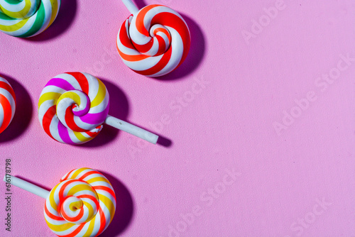 Flat lay sweet candy favorite of small children. Colorful lollipops, candies, chocolates. Pink background