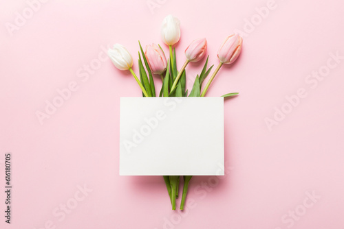 Fototapeta Naklejka Na Ścianę i Meble -  Composition with blank card and beautiful flowers tulip on coloredbackground. top view with space for you desing
