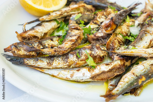 Plateful of Grilled Sardines Served with a Slice of Lemon in a Restaurant in Greece