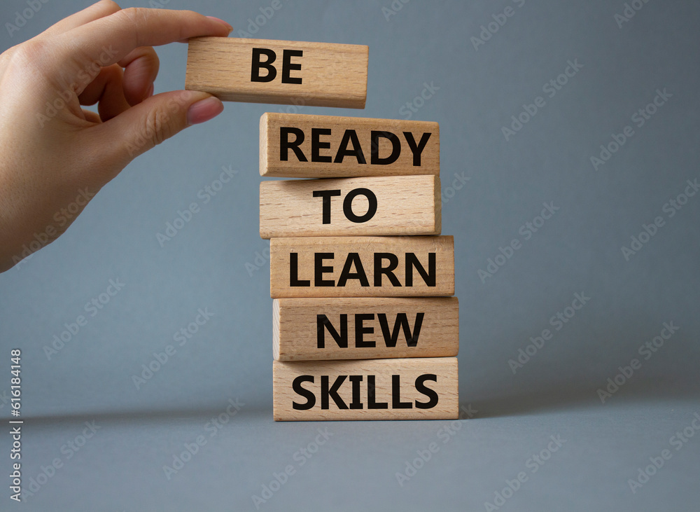 Learn new skills symbol. Concept words Be ready to Learn new skills on wooden blocks. Beautiful yellow background. Businessman hand. Business and Learn new skills concept. Copy space. Learn new skills symbol. Concept words Be ready to Learn new skills on wooden blocks. Beautiful yellow background. Businessman hand. Business and Learn new skills concept. Copy space.