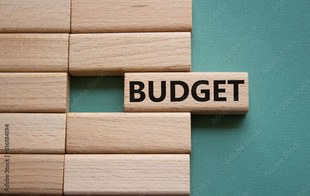 Budget symbol. Concept word Budget on wooden blocks. Beautiful grey green background. Business and Budget concept. Copy space. Budget symbol. Concept word Budget on wooden blocks. Beautiful grey green background. Business and Budget concept. Copy space.