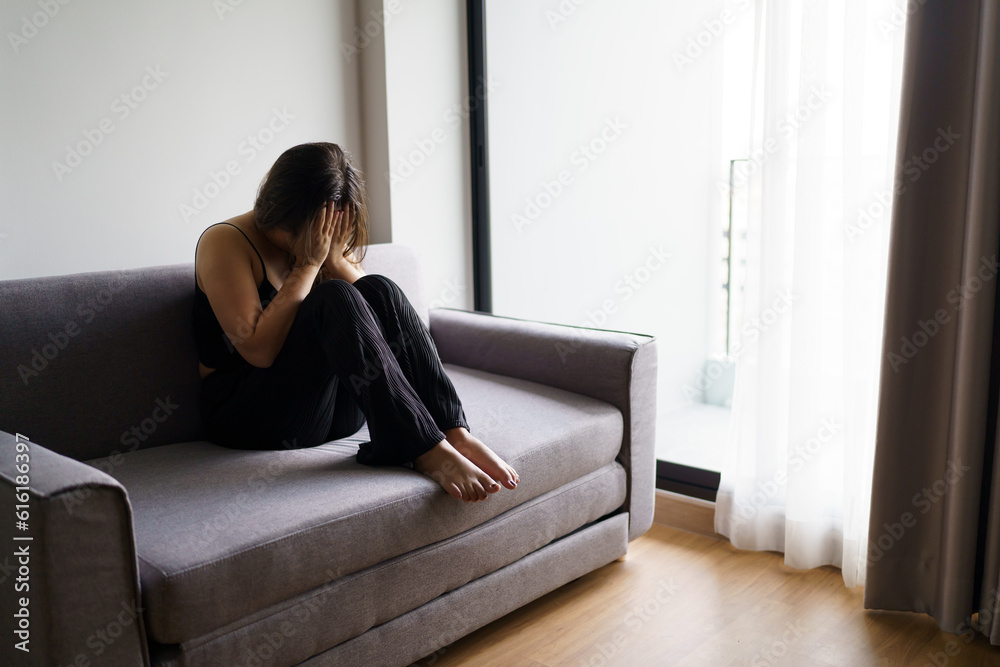 Sad woman thinking about problems sitting on a sofa upset girl feeling lonely and sad from bad relationship or Depressed woman disorder mental health. Sad woman thinking about problems sitting on a sofa upset girl feeling lonely and sad from bad relationship or Depressed woman disorder mental health.