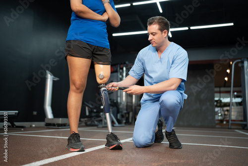 Caucasian assisted male physiotherapist take care Asia woman with prosthetic leg 