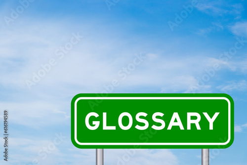 Foto Green color transportation sign with word glossary on blue sky with white cloud