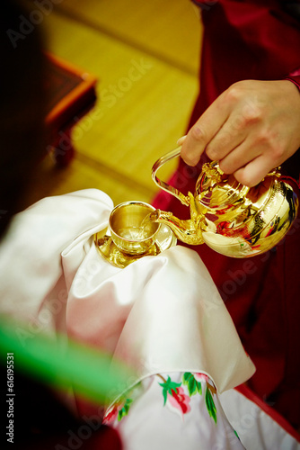 Pouring alcohol into a traditional Korean wine glass photo