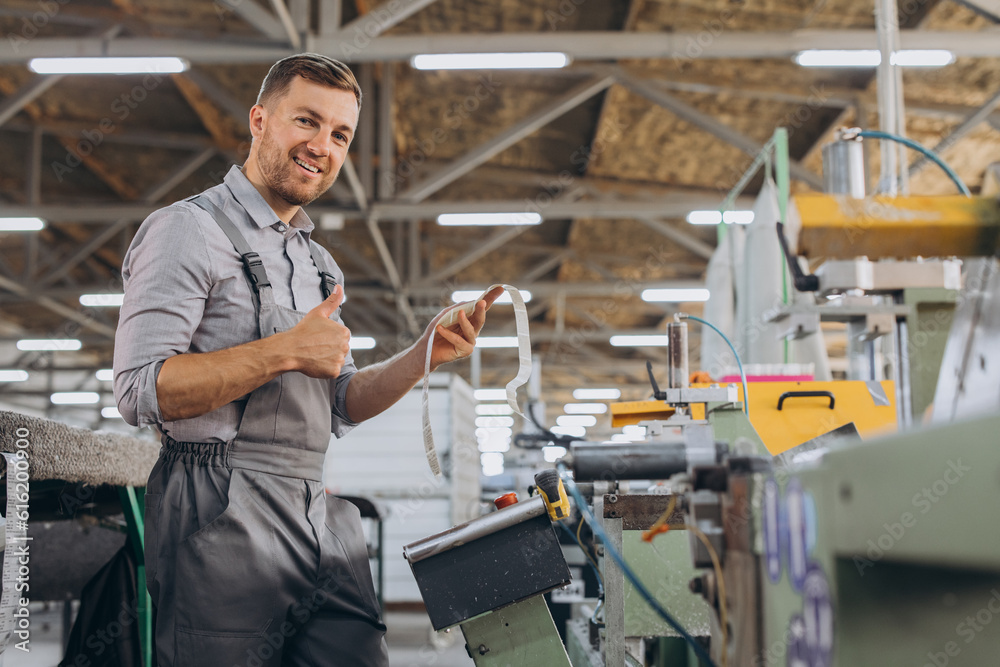 Factory male bearded worker is programming a CNC milling machine with copy space.