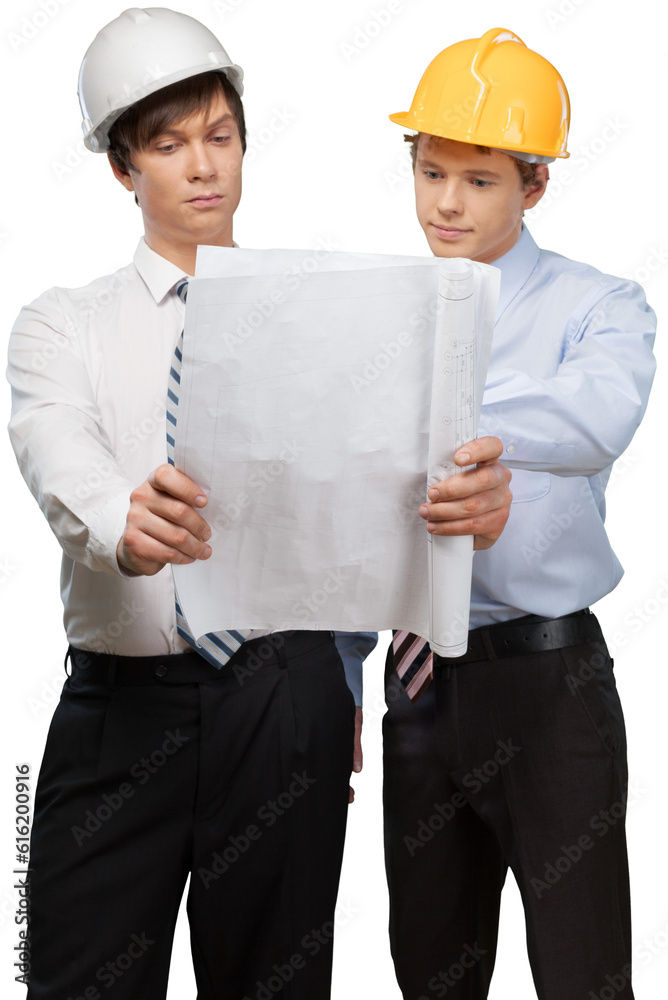 Two men in hardhats at construction site with blueprints Two men in hardhats at construction site with blueprints