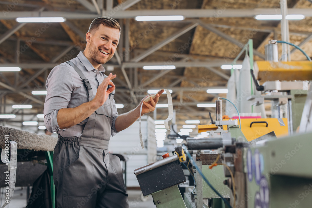 Factory male bearded worker is programming a CNC milling machine with copy space.