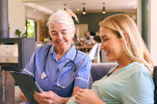 Tableau sur toile Senior Midwife With Digital Tablet Visiting Pregnant Woman At Home With Family I