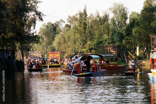 Mexico City,Family enjoying a warm Saturday afternoon with a traditional promenade on a Trajinera boat in Xochimilco channels or canals at sunset.