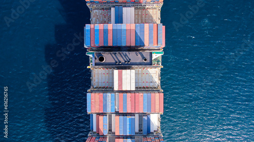 Ultra large container ship aft part of the vessel with many loaded containers and scrubber funnel tubes. View from top.