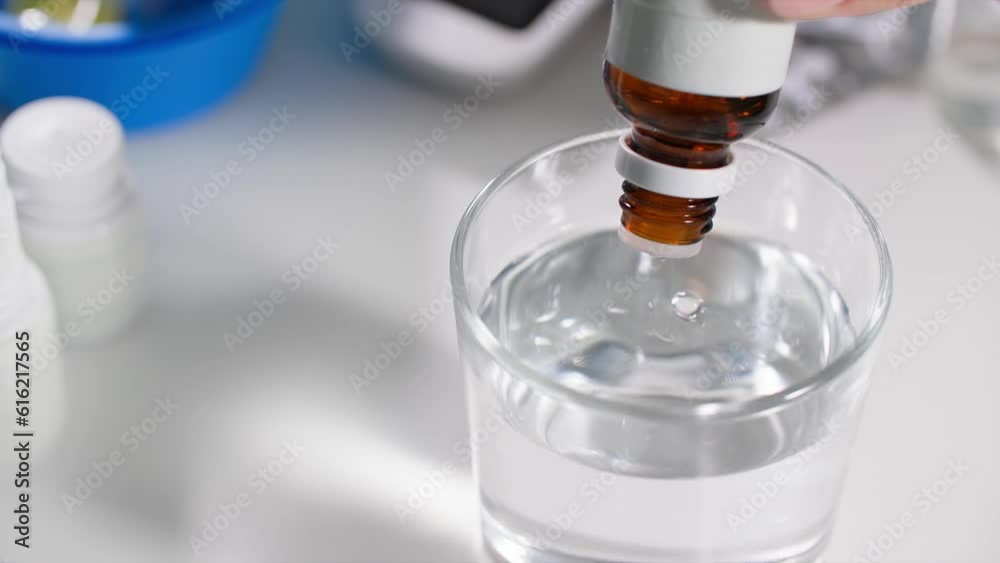 normalization of pressure, woman drips drops from a bottle with a dispenser into a transparent glass of water, a close-up plan
