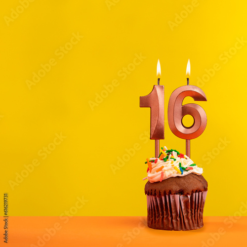 Candle with flame number 16 - Birthday card on yellow background