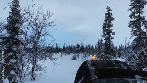 Slow mo. View from the snowmobile at speed. Large snowy field in winter. Evening sunset in Siberia. Red sun at sunset photo