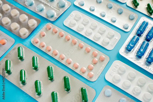 Pharmaceutical drugs, antibiotics, pills. Colorful pills on a blue background, capsule pills