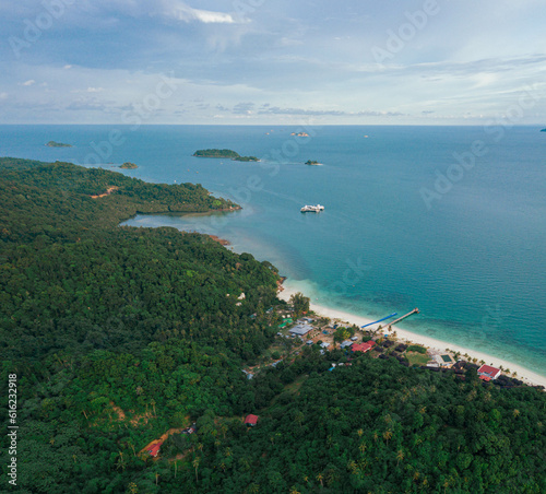 Panoramic aerial drone view of tropical island scenery with lush green forest trees at Tinggi Island or Pulau Tinggi in Mersing, Johor, Malaysia