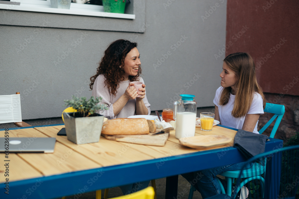 Mother and daughter are having breakfast together in the backyard. Mother and daughter are having breakfast together in the backyard.