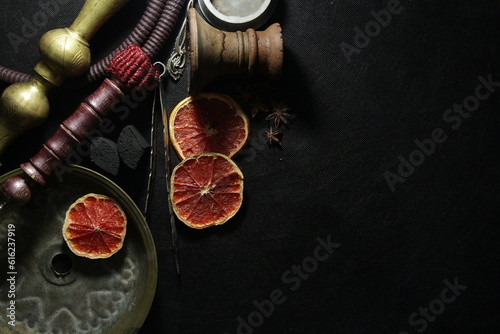 bowl with tobacco for hookah. nargile smoking. berries and fruits on a dark background.