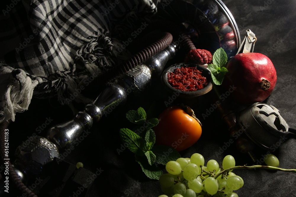 Obraz premium bowl with tobacco for hookah. nargile smoking. berries and fruits on a dark background.