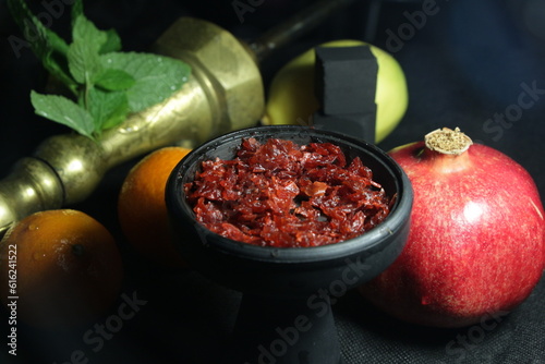 bowl with tobacco for hookah. nargile smoking. berries and fruits on a dark background.